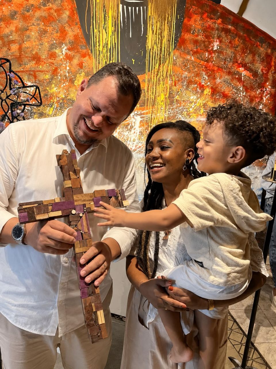 Adauto Werneck com sua família segurando uma cruz de madeira